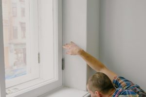 man inspecting a window